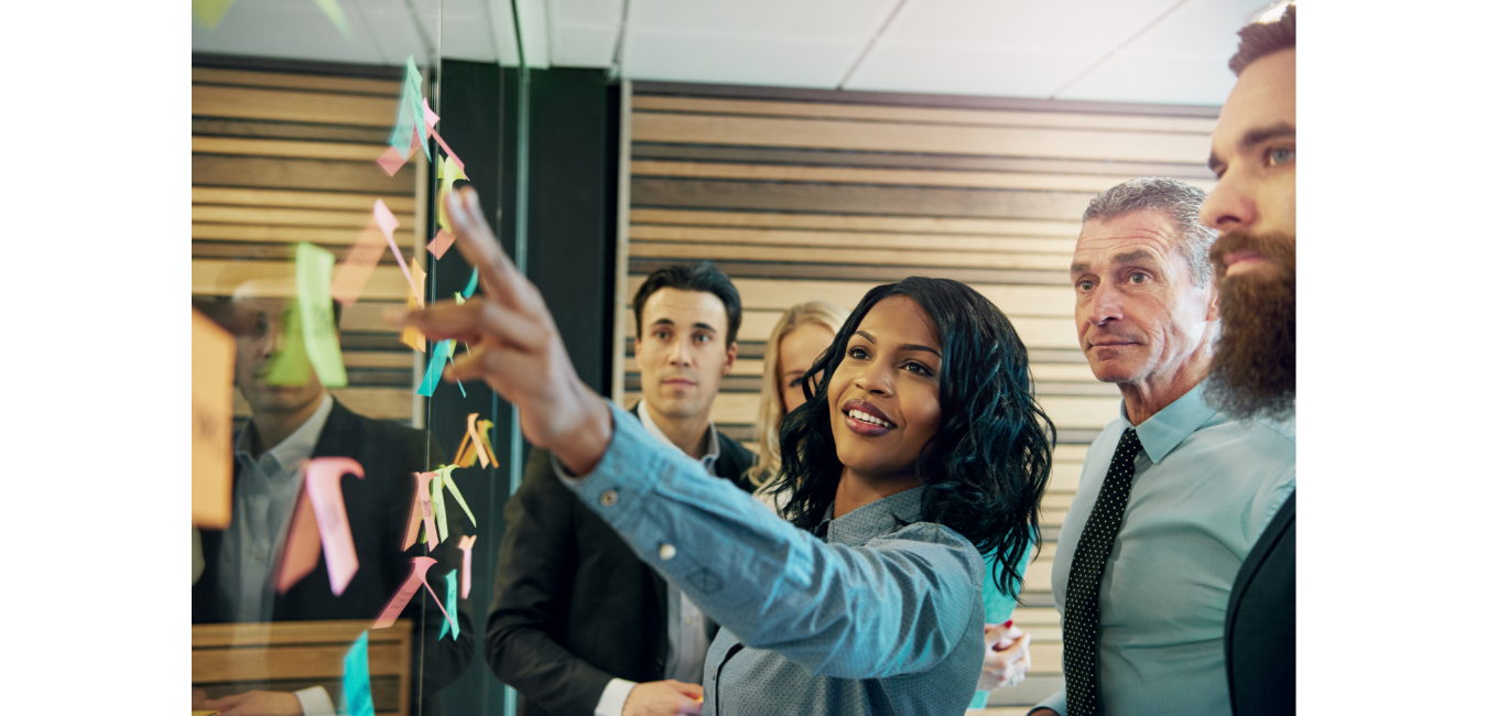 woman showing post-it notes to team