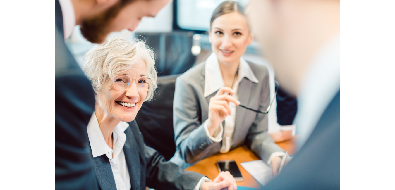 older lady and man and woman talking in office